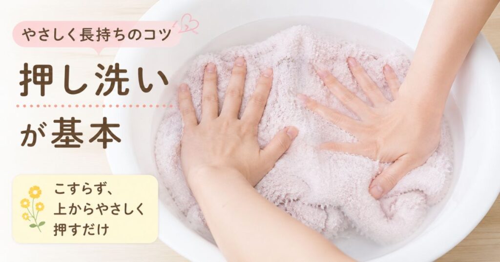 洗面器のぬるま湯の中で両手を広げてジェラピケを押し洗いしている手元