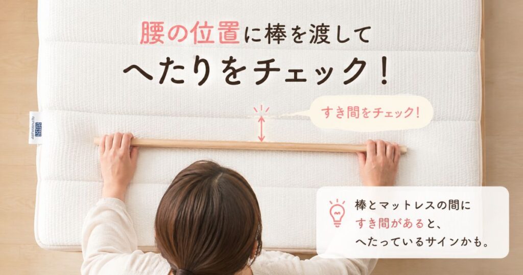エアウィーヴの買い替えの見極めとして腰の位置のへこみを棒を渡して確認している様子