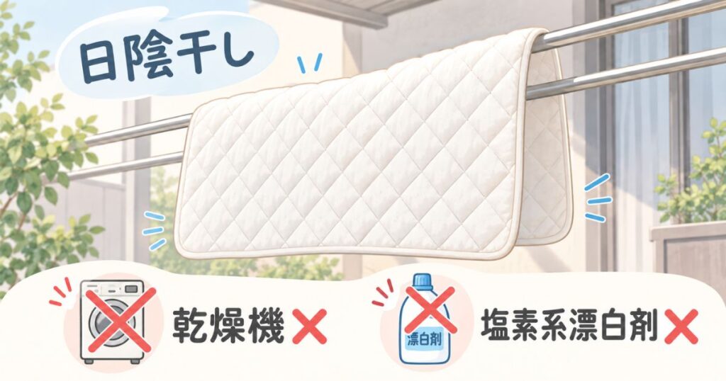 洗い終えた敷きパッドを日陰で物干し竿2本にかけて乾かしている様子
